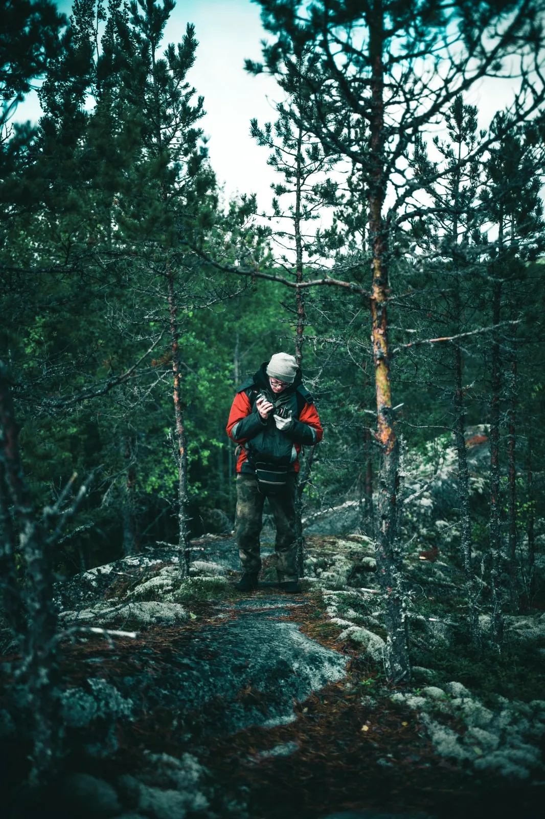 Vandrare i skog med jacka och packning